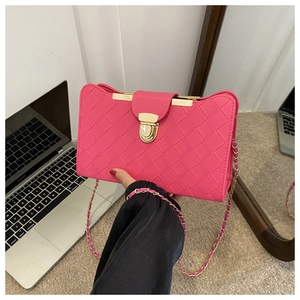 Hot pink woven shoulder bag detail with gold metal clasp and leather chain strap closeup