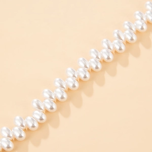 Detailed macro view of white irregular seed pearls with high luster in a neat row