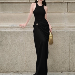 Détail des plis à la taille et de la boucle dorée sur une robe longue noire sans manches