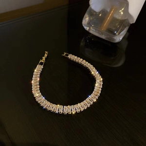 Elegant gold bracelet with AAA square cut cubic zirconia crystals on a dark background