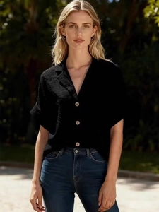 Maglia nera a maniche corte con bottoni da donna e jeans aderenti blu scuro