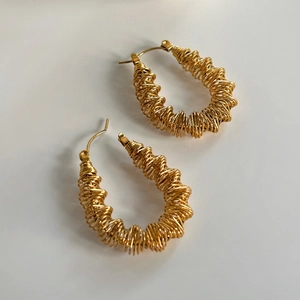 Detailed view of 18k gold plated stainless steel wave spring hoop earrings for women