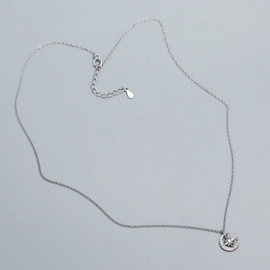 Macro shot of silver crescent moon and star pendant with sparkling cubic zirconia inlay