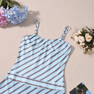 Detailed view of blue and white striped summer dress with thin straps and floral accents