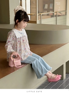 Detail view of pink glossy handbag with a triangular logo for kids fashion