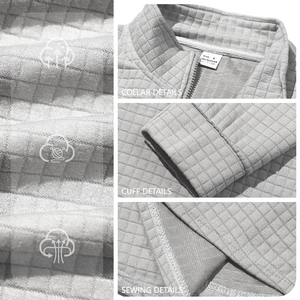 Detail view of grey quilted waffle fabric texture and stitching on men's half-zip pullover