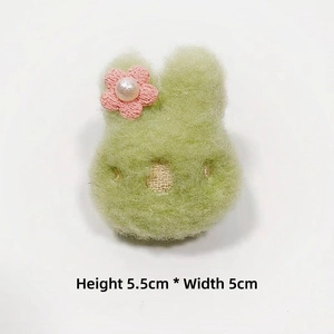 Detailansicht einer 5,5x5cm grünen Plüschhasen-Brosche mit rosa Blume und Perle