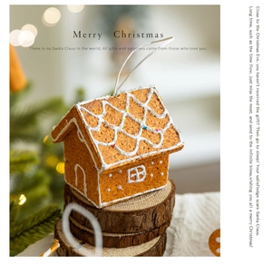 Close-up of brown gingerbread house ornament on rustic wood base with Christmas lights