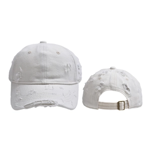 Close-up of distressed cream baseball cap featuring ripped details and metal back buckle