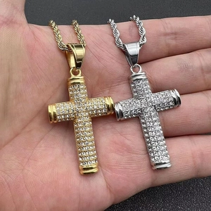 Macro detail of iced-out gold and silver cross pendants with shimmering rhinestones