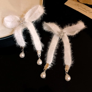 Detail of Christmas bow earrings with white fur, zircon snowflakes and pearl drops