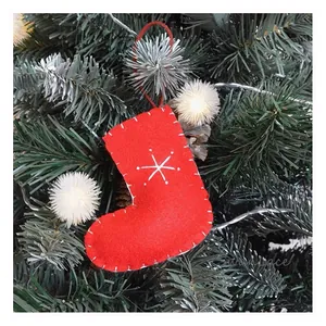 Detail of red wool felt Christmas stocking ornament with white snowflake embroidery