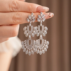 Gros plan de boucles d'oreilles vintage en argent avec zircons et design creux à pompon