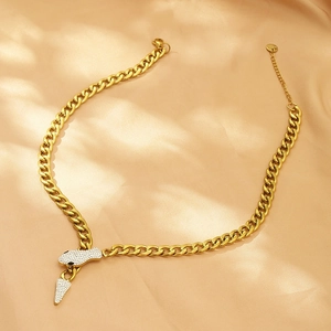 Detail of a golden cuban chain necklace with a luxury rhinestone-studded snake head closure