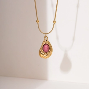 Detail of 18K gold snake chain necklace with pink rhodochrosite pendant and metal beads