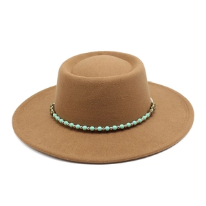 Close-up of brown wool felt boater hat featuring ethnic turquoise beaded band decoration
