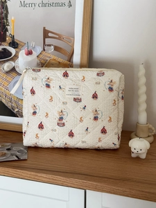 Detail of quilted cotton makeup bag with circus prints and durable zipper closure