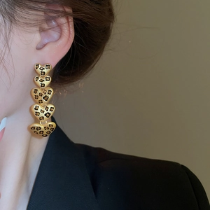 Detailansicht langer Leopard-Herz-Ohrringe an einem Modell mit Gold-Finish