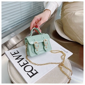 Detailed close-up of mint green jelly Cambridge bag with golden buckle and chain strap