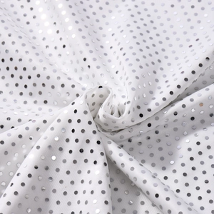 Gros plan de sequins argentés sur tissu blanc pour une robe de soirée sophistiquée