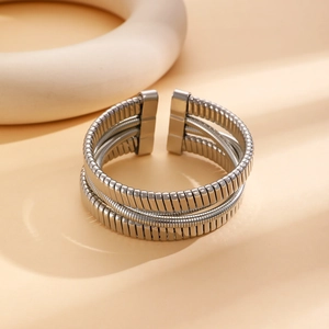 Dettaglio di bracciale rigido a molla multistrato argento con terminali rettangolari