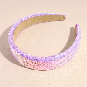 Detailed view of pink sequined wide headband with soft beige fabric inner lining