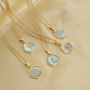Gold hexagonal necklace with iridescent shell inlay and capital letter pendant on thin chain