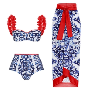 Three-piece porcelain print bikini set with red floral straps and matching sarong skirt