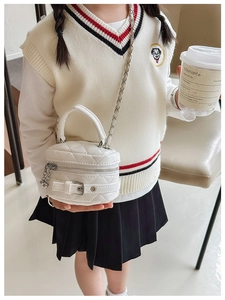 Detail showing white quilted mini bag with gold chain strap and buckle closure