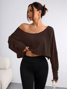 Detail of off-shoulder cropped long sleeve top in coffee brown paired with black pants