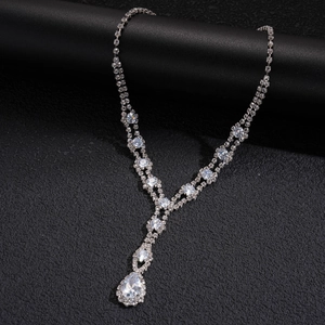 Macro shot of silver-colored Y-shaped necklace with shimmering pear-cut drop pendant