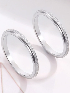 Detailed view of silver stainless steel rings with a matte frosted texture and polished finish