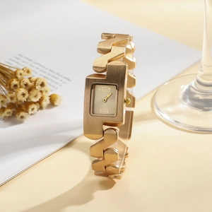 Detail of elegant gold women's watch with architectural Z-link strap and brushed finish