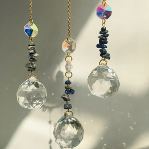 Detail of crystal suncatcher with blue gravel stones and faceted clear glass ball