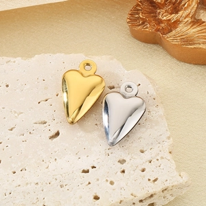 Pendenti a cuore lucidati in oro e argento esposti su una pietra strutturata