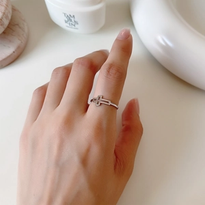 Close-up of S925 sterling silver hollow cross open ring worn on a finger