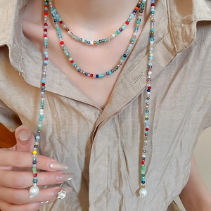 Close-up of bohemian multi-layered colorful beaded necklace with white pearls