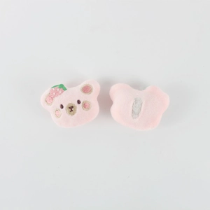 Detail of pink plush bear head with strawberry embroidery and back attachment piece