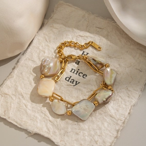 Detail of double-layer stainless steel bracelet with irregular natural shell beads