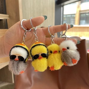 Close-up of cute plush duck keychains with yellow helmets and cool sunglasses