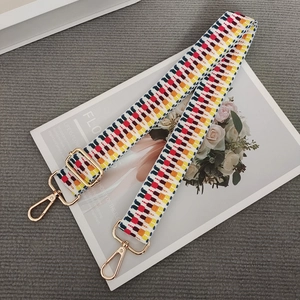 Detail of colorful geometric woven strap with gold metal hooks and adjustable buckle