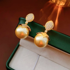 Dettaglio di orecchini di perle placcati oro 18 carati con accenti di diamanti brillanti