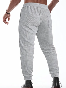 Detail view of men's light grey waffle knit pants featuring elastic waist and rear pocket