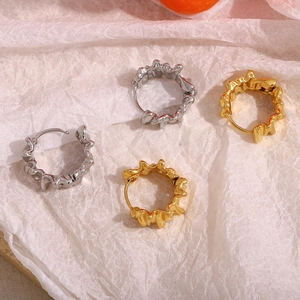 Detailed shot of irregular lava texture earrings in 18K gold and silver finishes