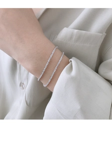 Close-up of minimalist silver double-layer fine chain bracelet on a female wrist