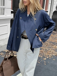 Women's dark blue double-breasted jacket for casual vacation style in urban autumn street