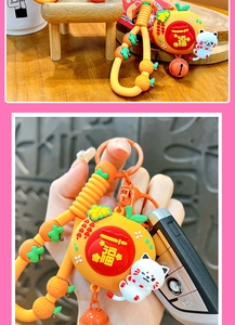 Close-up of cute lucky cat keychain with rotating Fu blessing charm and orange beads