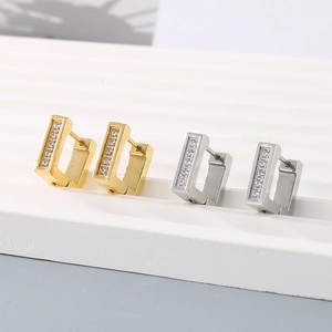 Macro shot of gold and silver square stainless steel earrings with zircon inlay