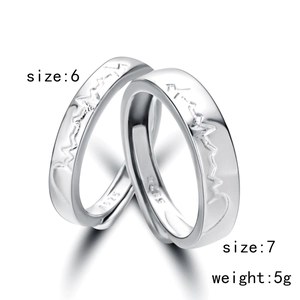 Detail view of S925 silver couple rings featuring engraved heart rate wave pattern
