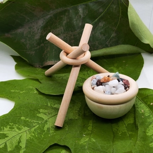 Handcrafted wooden tripod diffuser set with essential oil bowl on natural green leaves